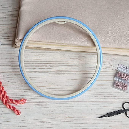 Plastic embroidery hoop with flexible rubbery ring.